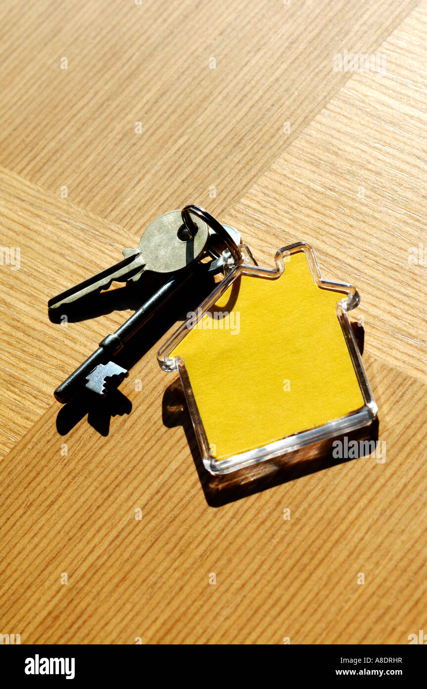 House keys and house shaped keyring on wooden table Stock Photo