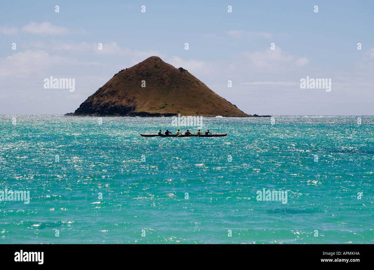 Outrigger canoe going past one of the Mokulua Islands, Lanikai, Oahu ...