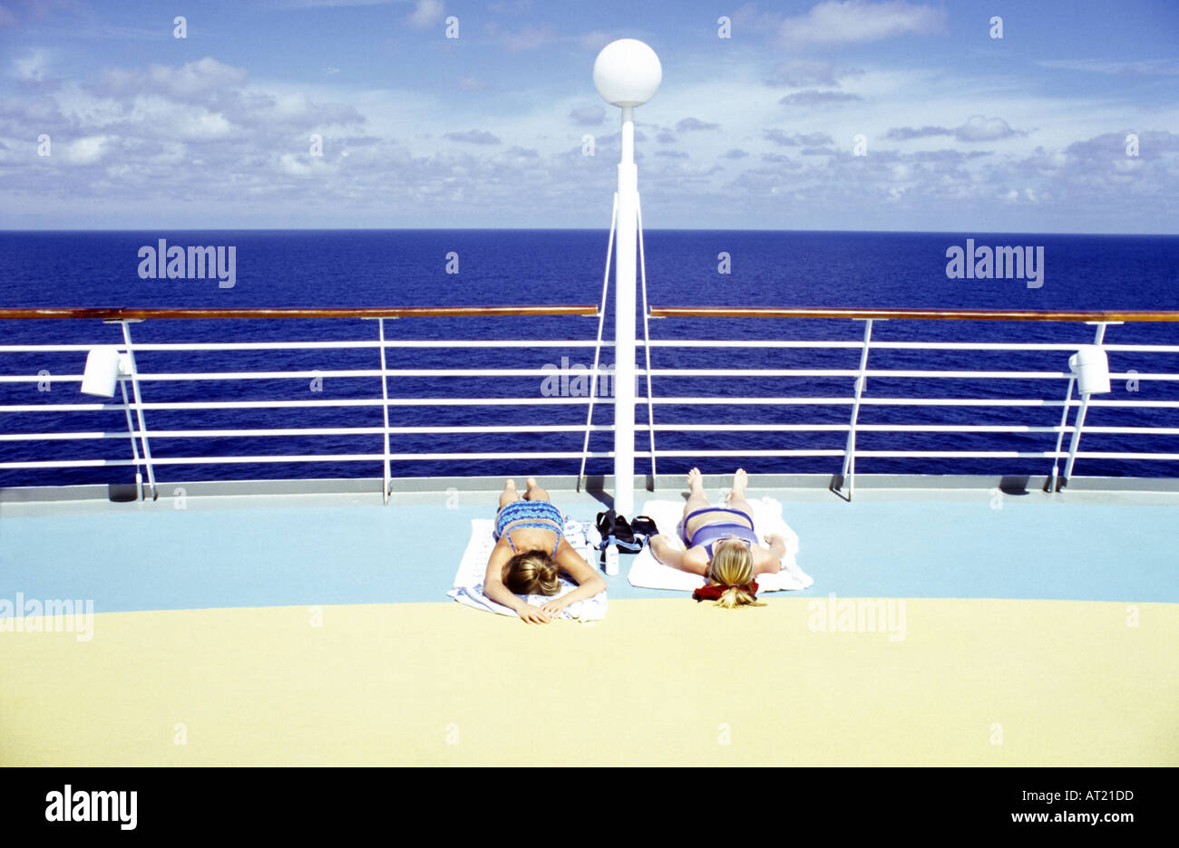 Two women sunbathing on the deck of a cruise ship Stock Photo