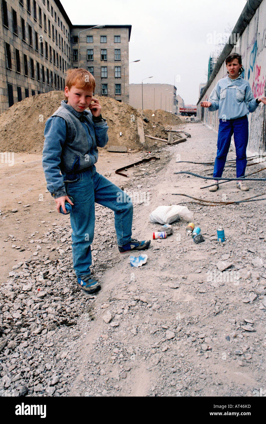 The Fall of the Berlin wall, 1989. A children spray paint rocks to sell as genuine graffiti from the wall. Stock Photo