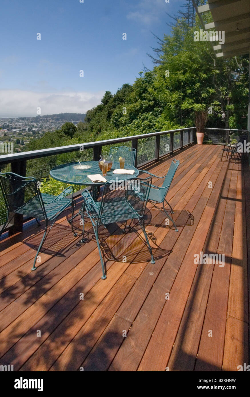 Wooden deck with table and chairs and a view Stock Photo