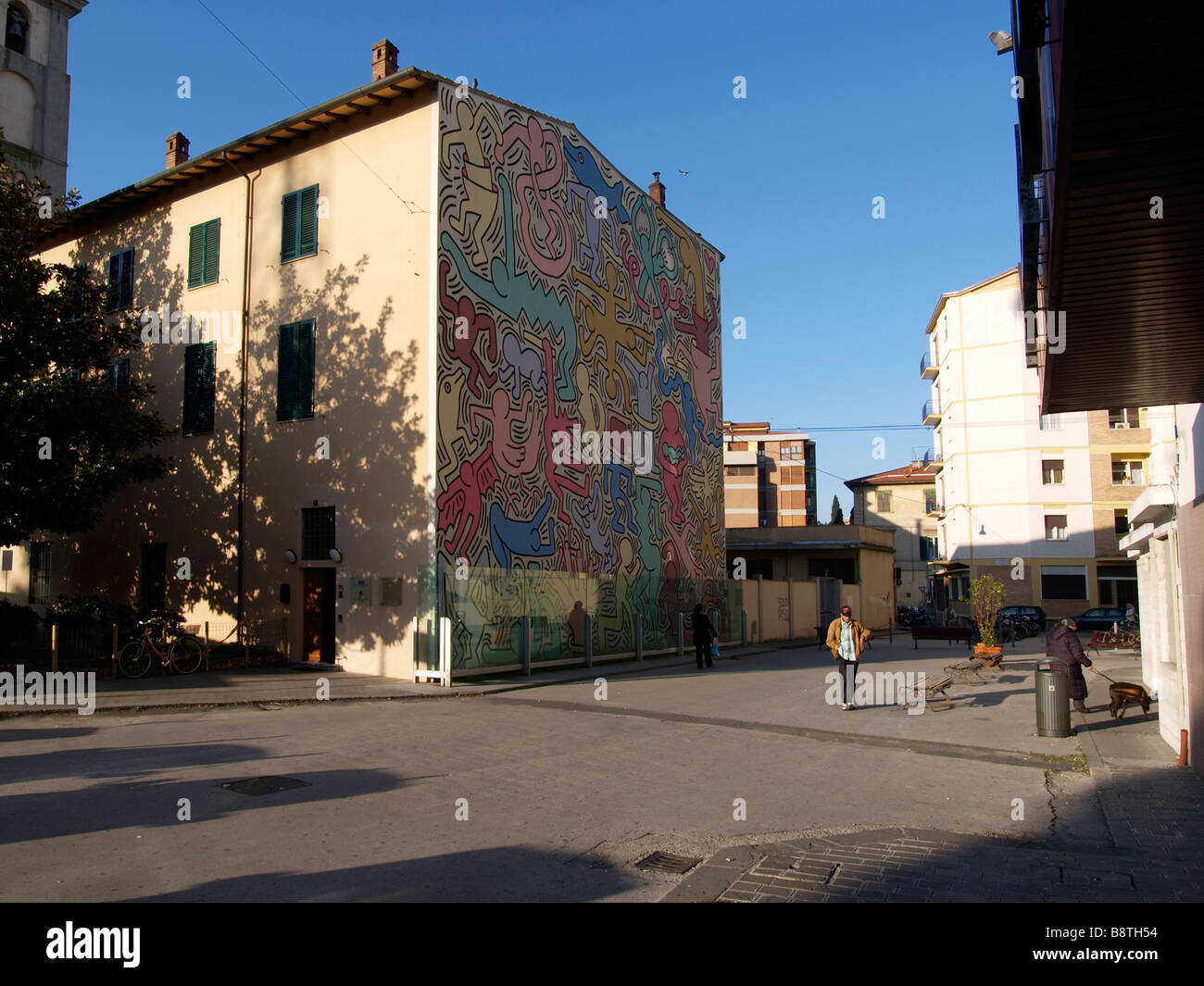 Large colorful mural by world famous US graffiti artist Keith Haring on the side of a building in Pisa Tuscany Italy Stock Photo