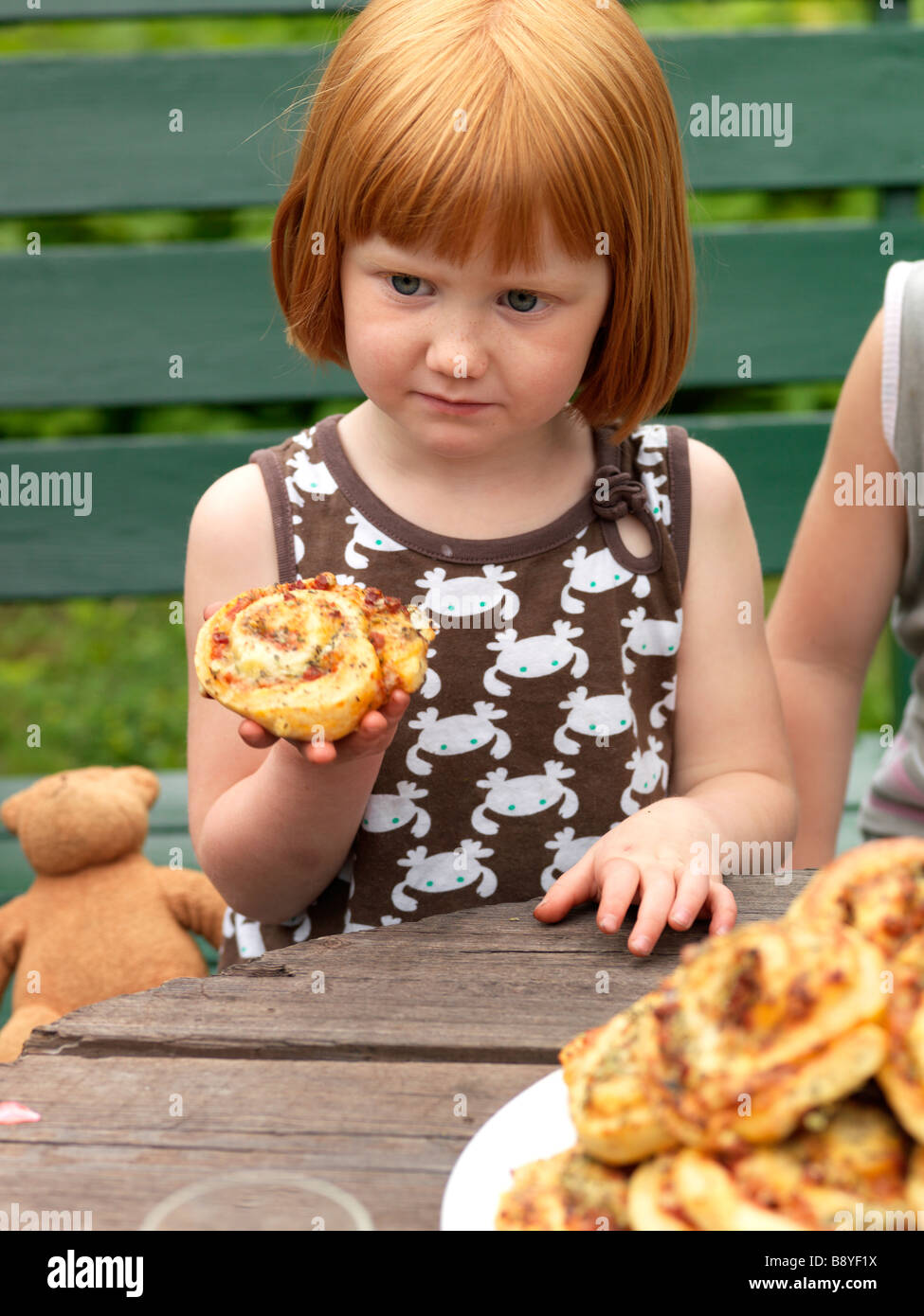 A girl eating a pizza bun Stock Photo - Alamy