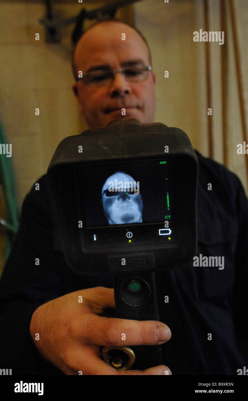 Fireman showing display on MSA thermal imaging Camera.  Note glasses block out some of heat signature. Stock Photo