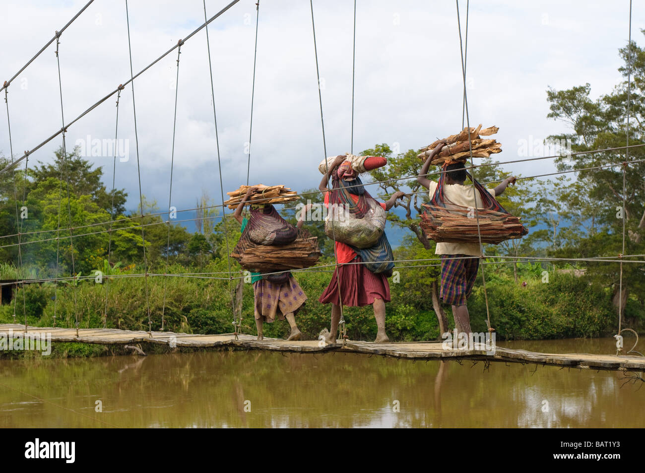 Papuan women crossing bridge Wamena Papua Indonesia Stock Photo