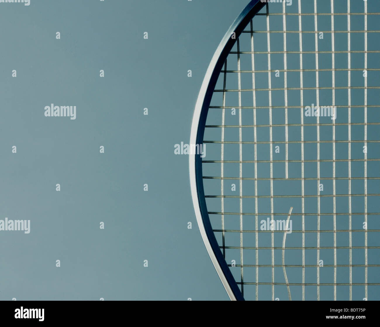 studio image of tennis racket with a snapped string. Stock Photo