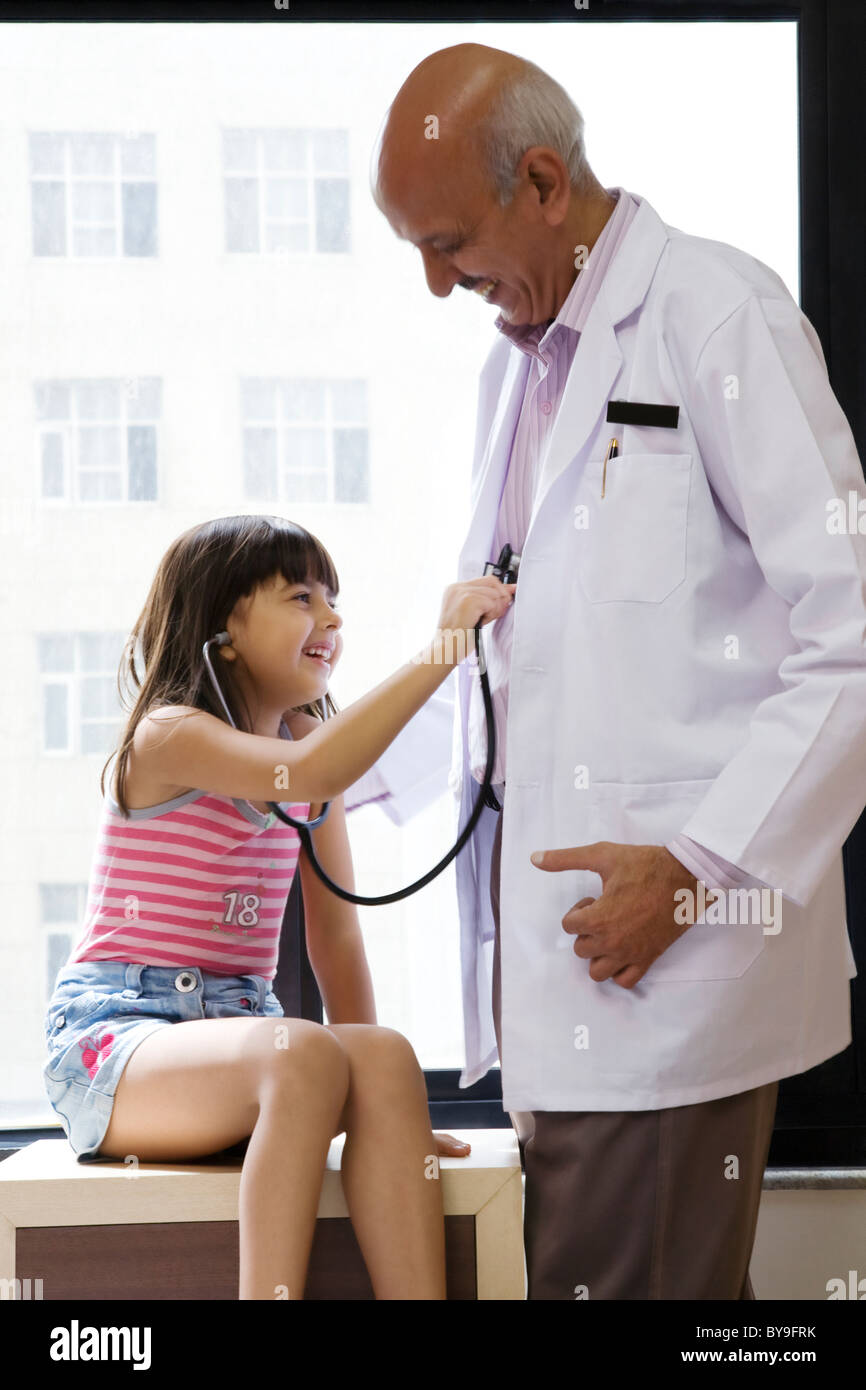 Girl checking a doctor's heartbeat Stock Photo