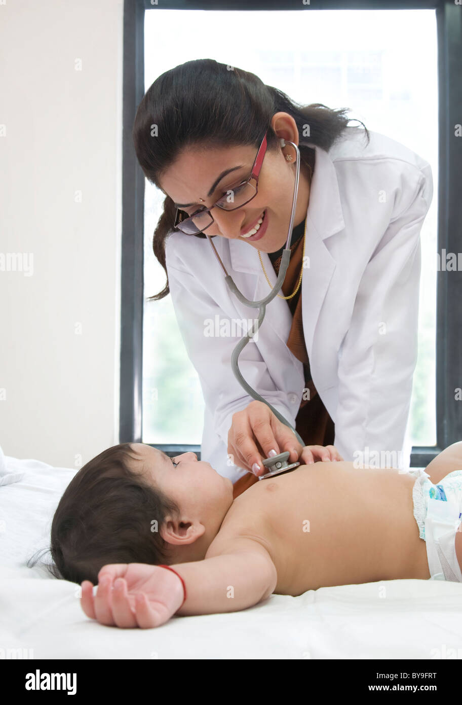 Doctor checking the heartbeat of a baby Stock Photo