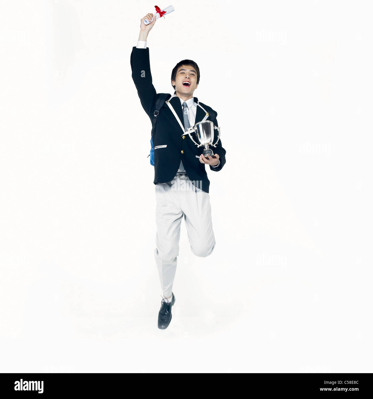 Portrait of boy standing jumping with trophy Stock Photo