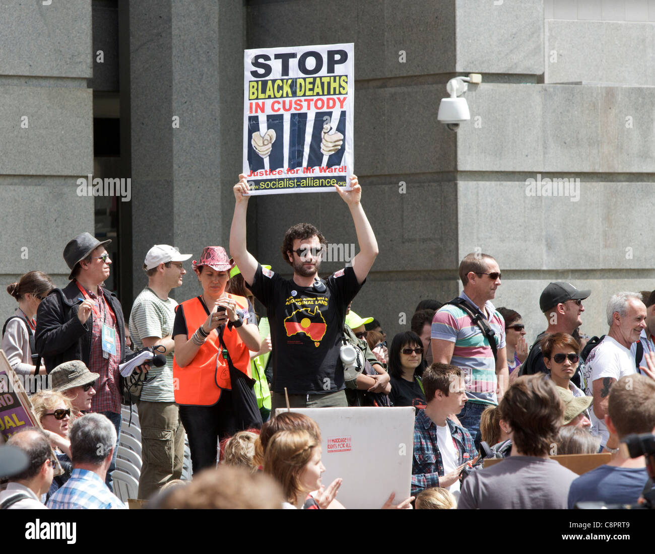 Protester holding a 'Stop Black Deaths in Custody' placard protesting about Aboriginal deaths in custody. Stock Photo