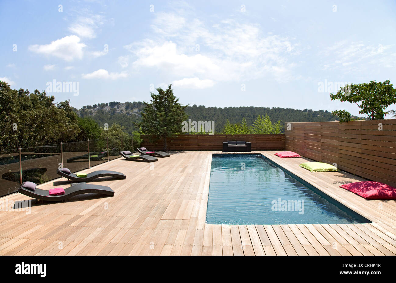 Lawn chairs and pool on modern deck Stock Photo