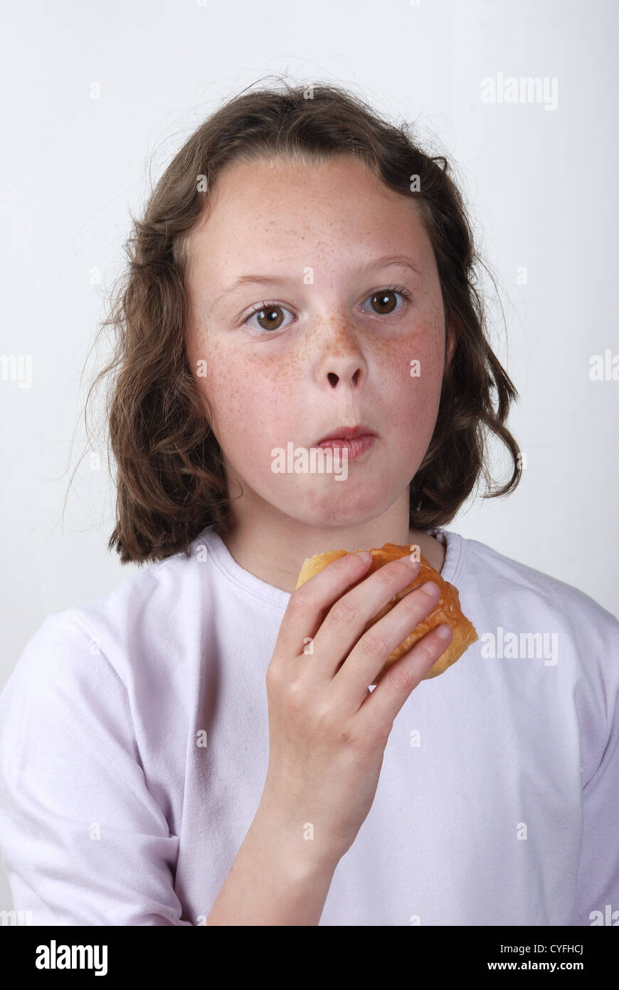 A young girl eating a bun Stock Photo - Alamy