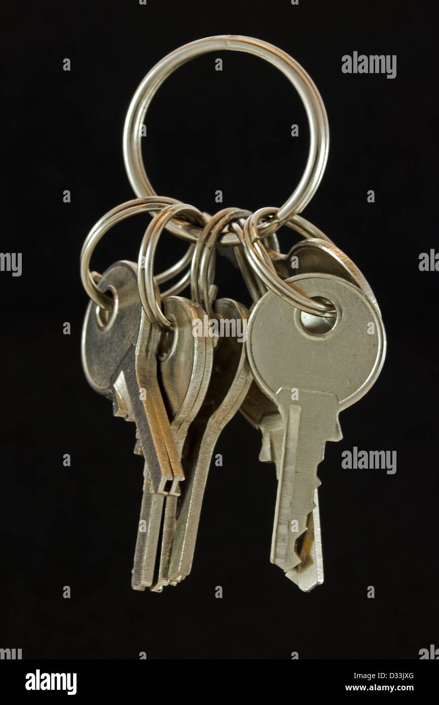 Set of steel small keys on keyring against black background Stock Photo