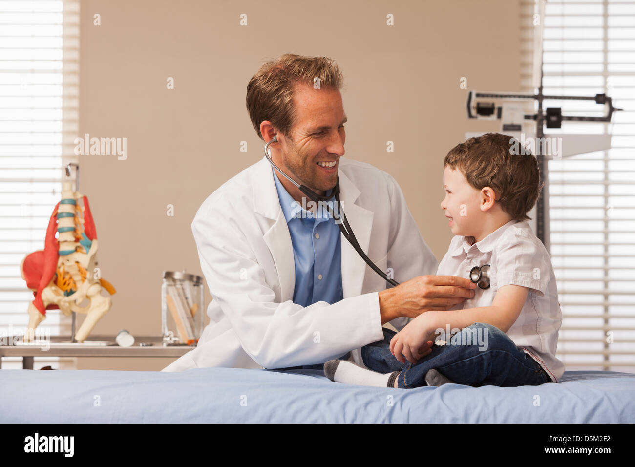 Pediatrician listening heartbeat of boy (2-3) Stock Photo