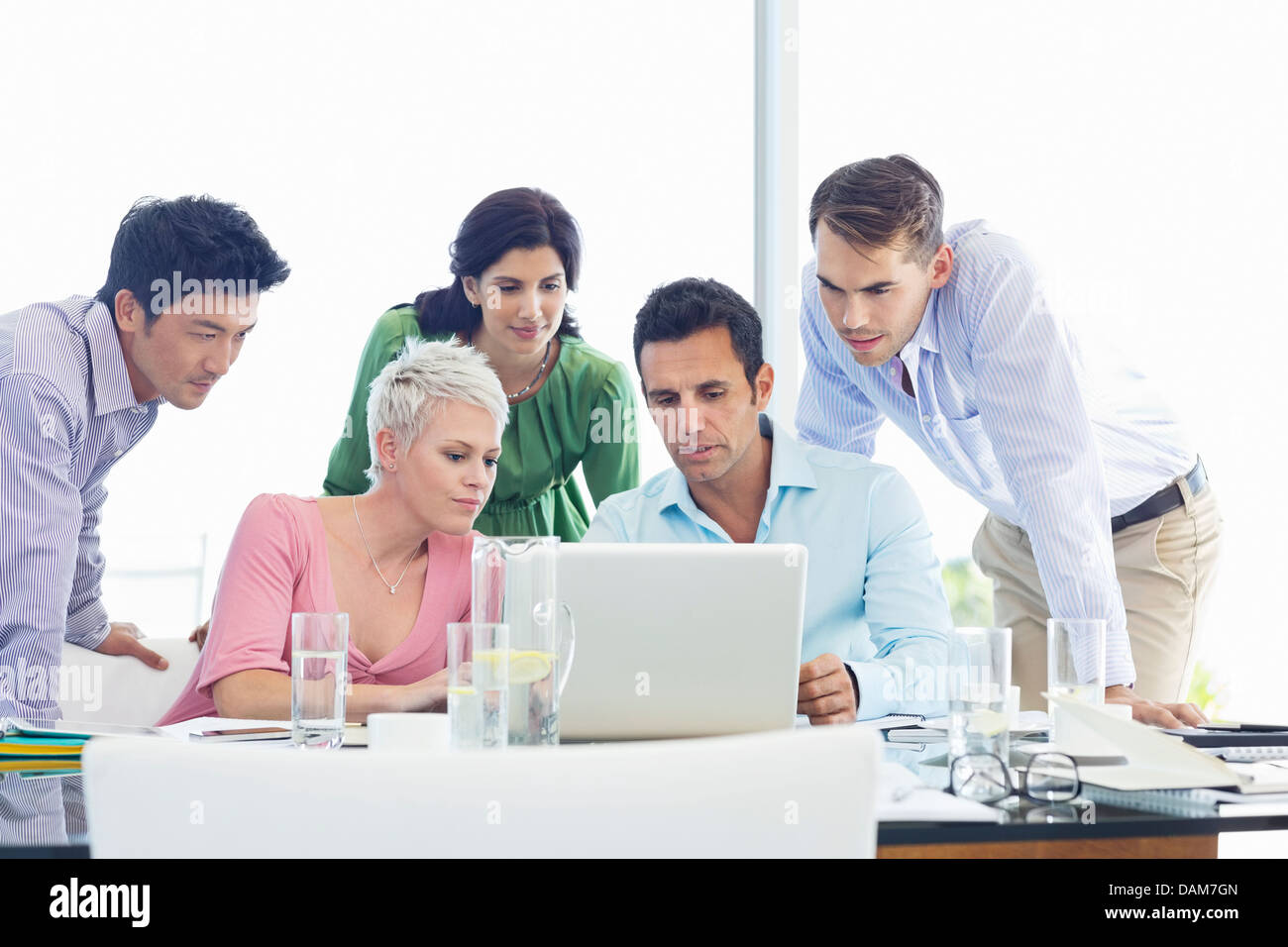 Business people using laptop in meeting Stock Photo