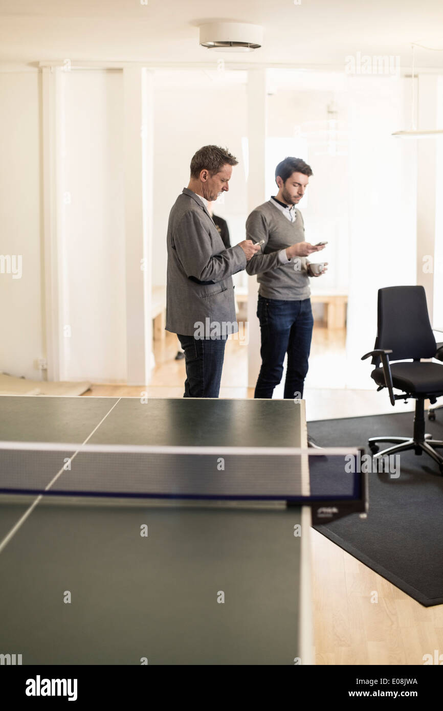 Businessmen using mobile phones in office Stock Photo