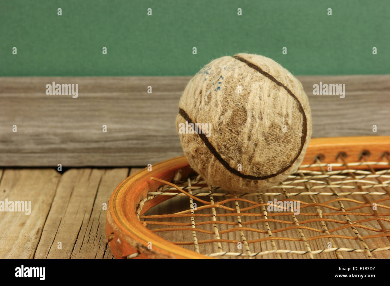 old tennis ball and racket on a wooden floor Stock Photo