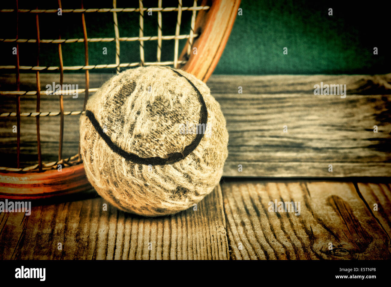 old tennis ball and racket on a wooden floor Stock Photo