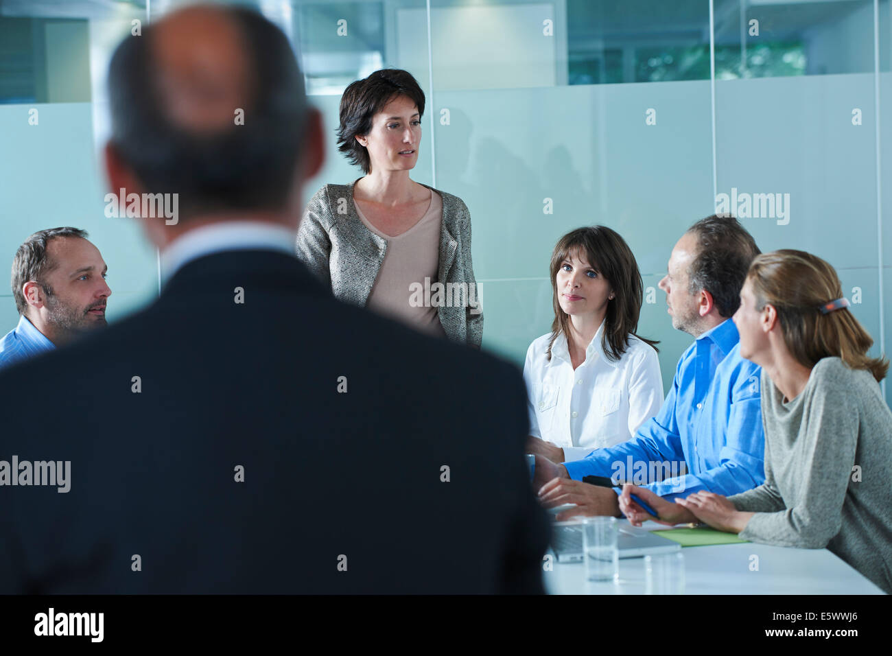 Businessmen and women arguing around boardroom table Stock Photo