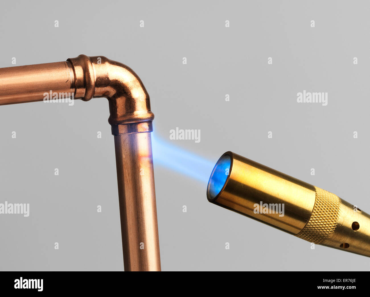 Blowtorch with flame on gray Stock Photo