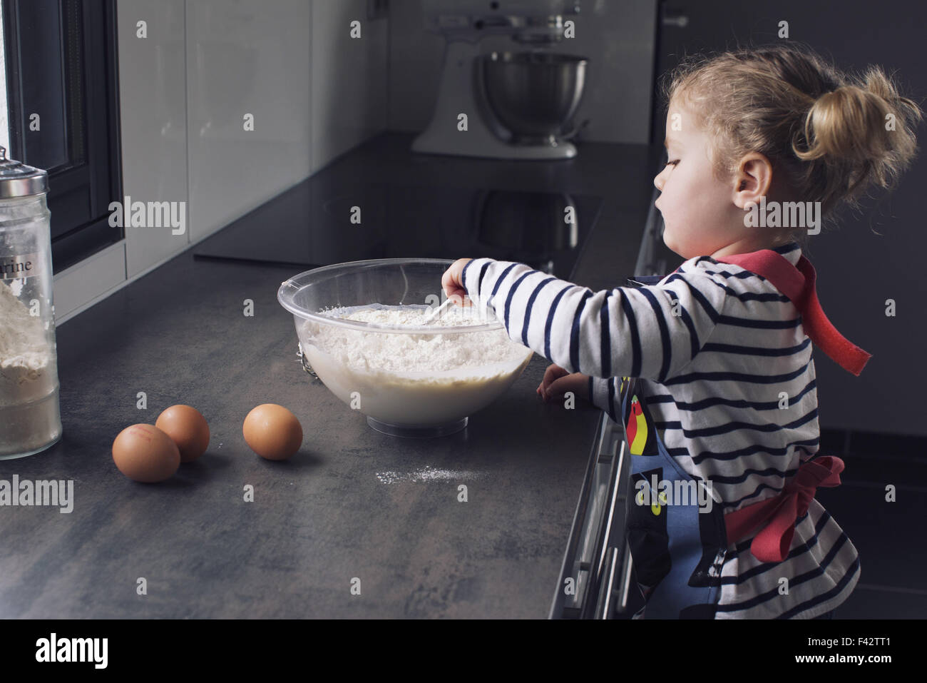 Little girl mixing batter Stock Photo