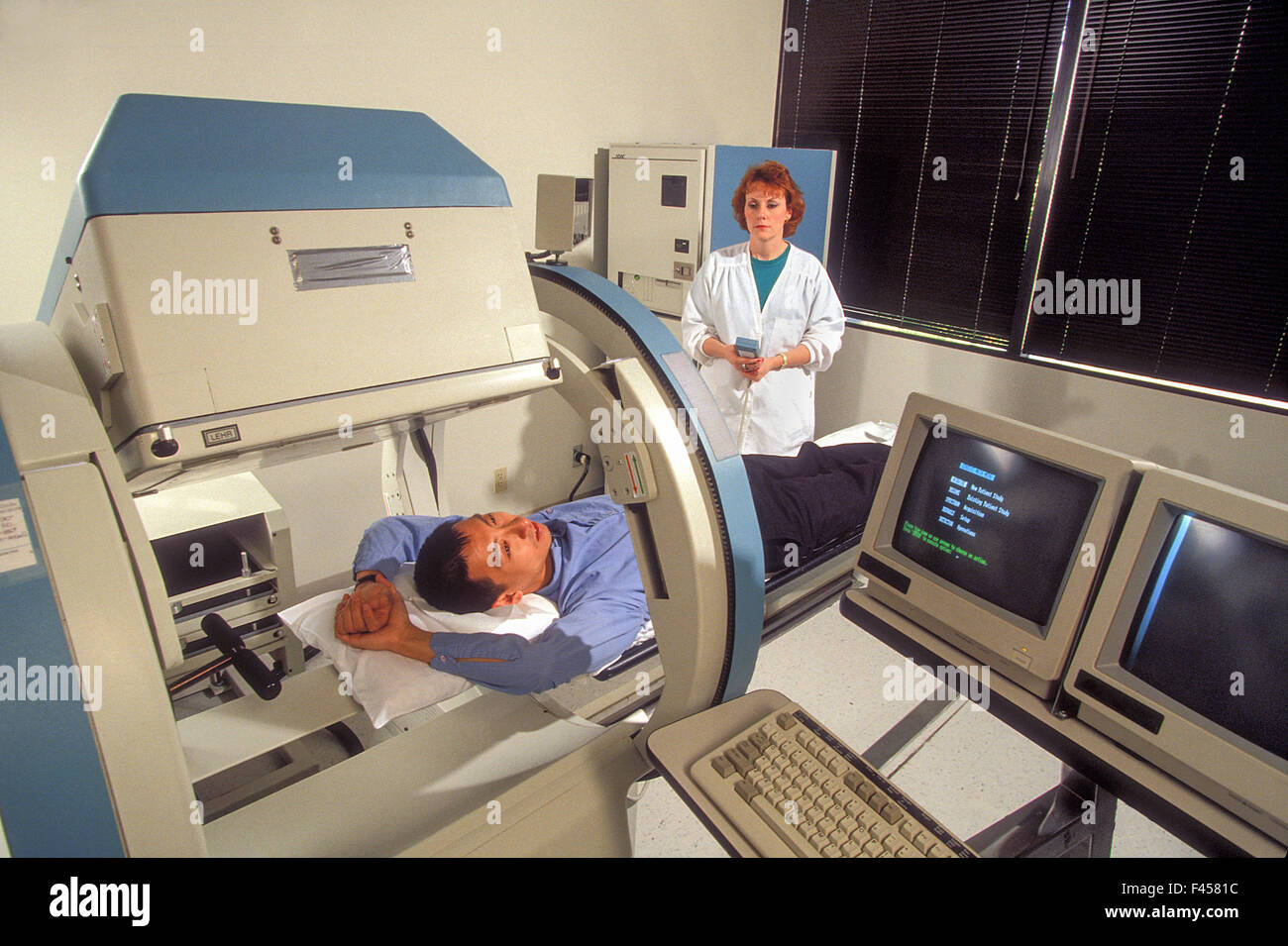 A radiology technician demonstrates an 'open' MRI machine in Laguna Hills, CA. Magnetic resonance imaging is used in radiology to investigate the anatomy and physiology of the body in both health and disease. MRI scanners use magnetic fields and radio wav Stock Photo