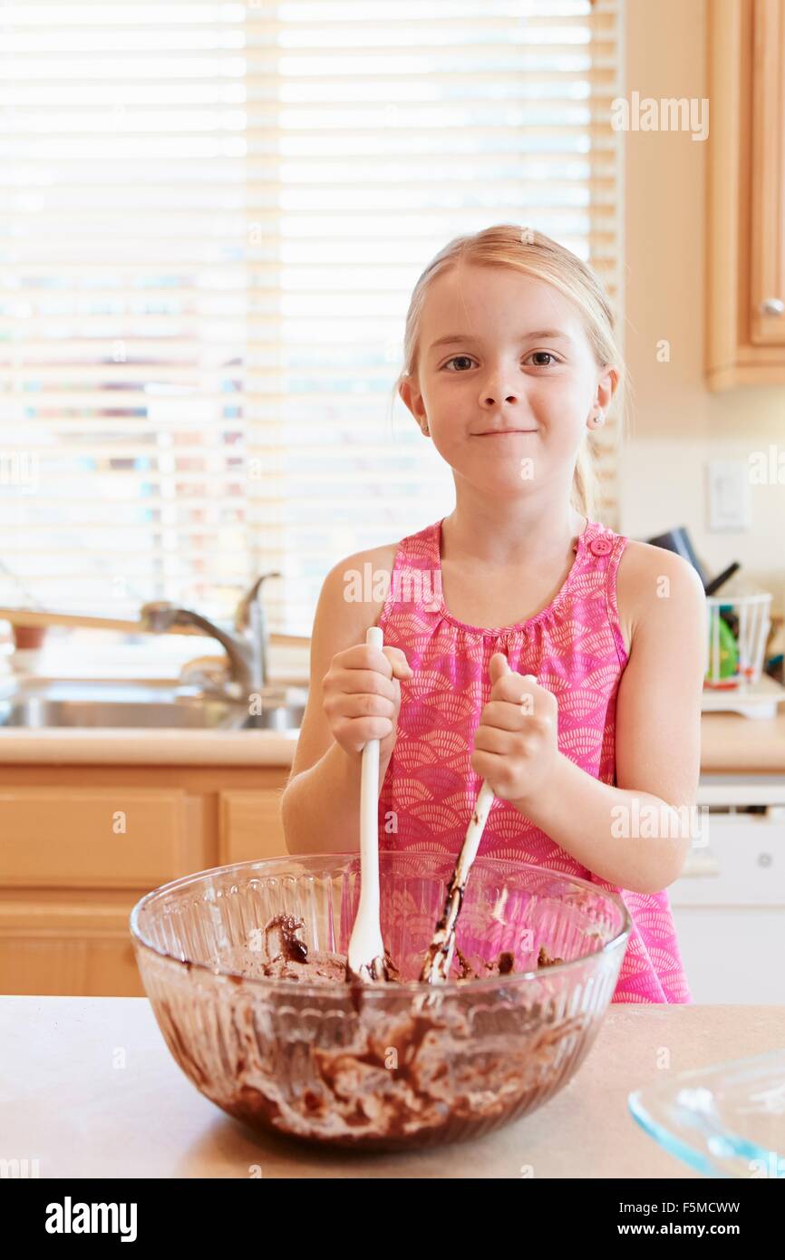 Girl melting chocolate in mixing bowl Stock Photo