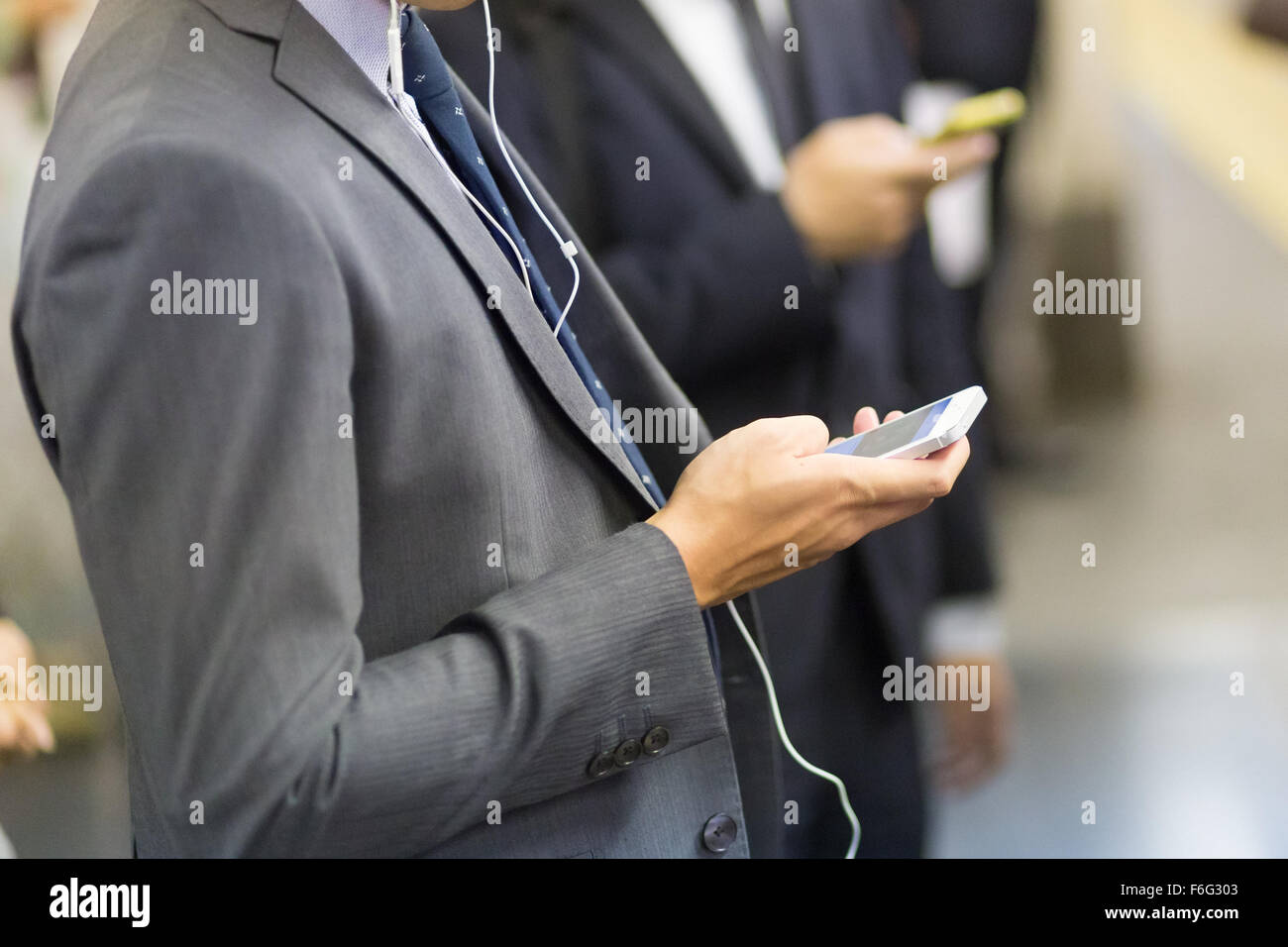 Businessmen using their cell phones on subway. Stock Photo