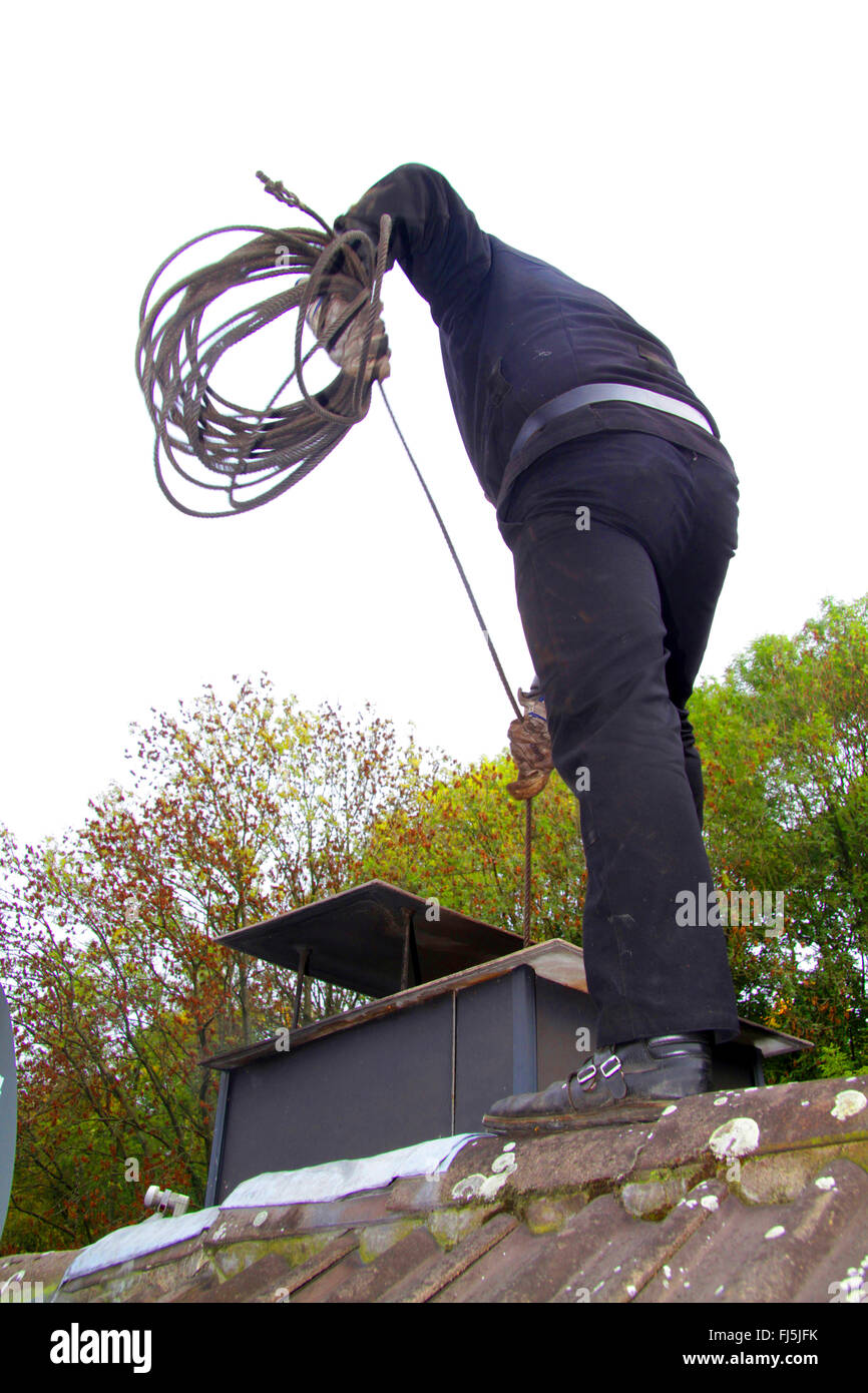 chimney sweeper at work on a roof, sweeping of a chimney, Germany Stock Photo