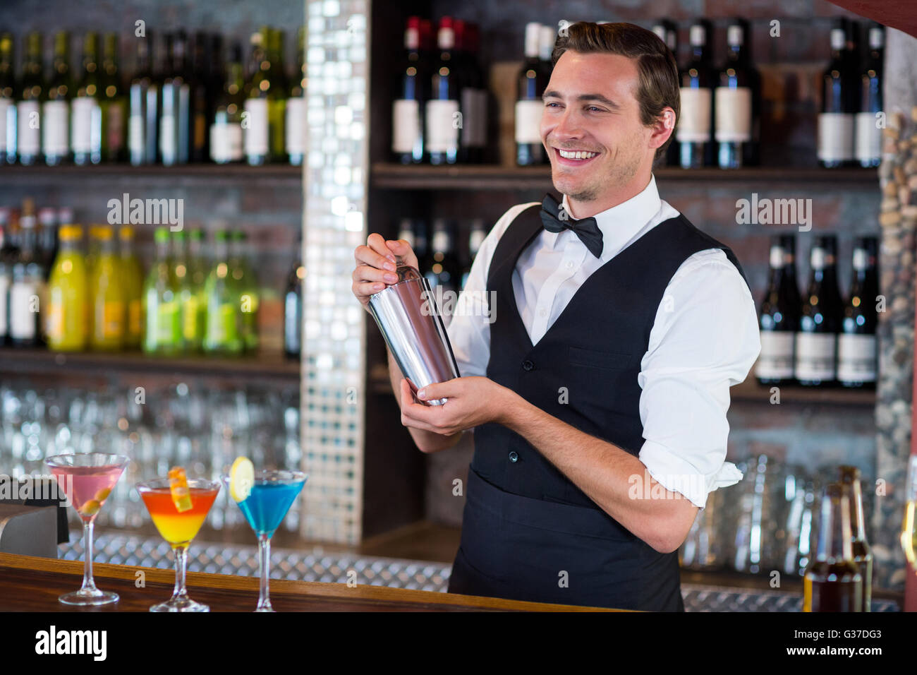 Bartender mixing a cocktail drink in cocktail shaker Stock Photo