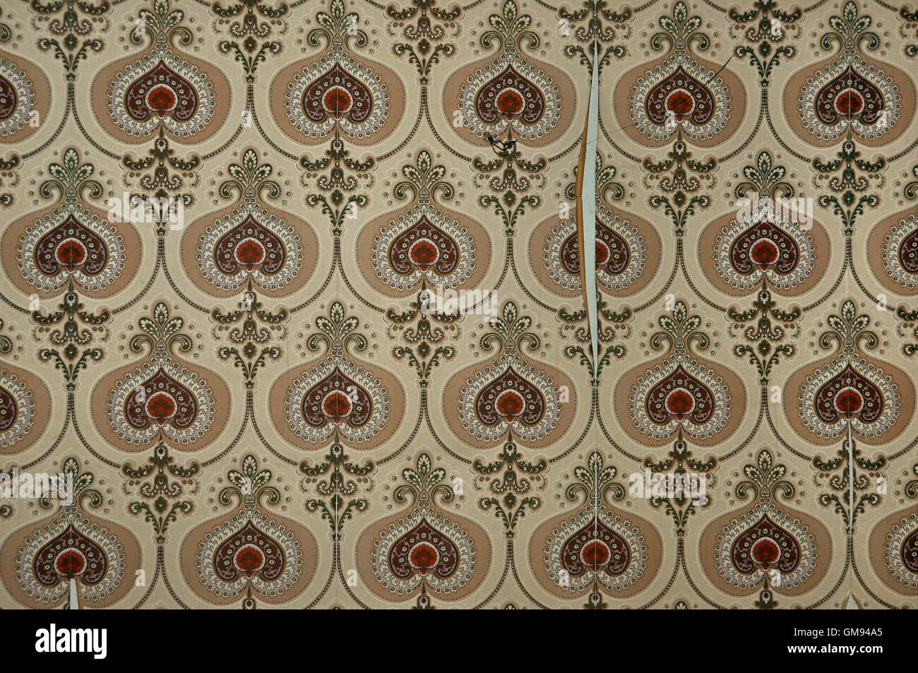 Vintage torn and dirty wallpaper with old fashioned pattern. Abstract retro background. Stock Photo