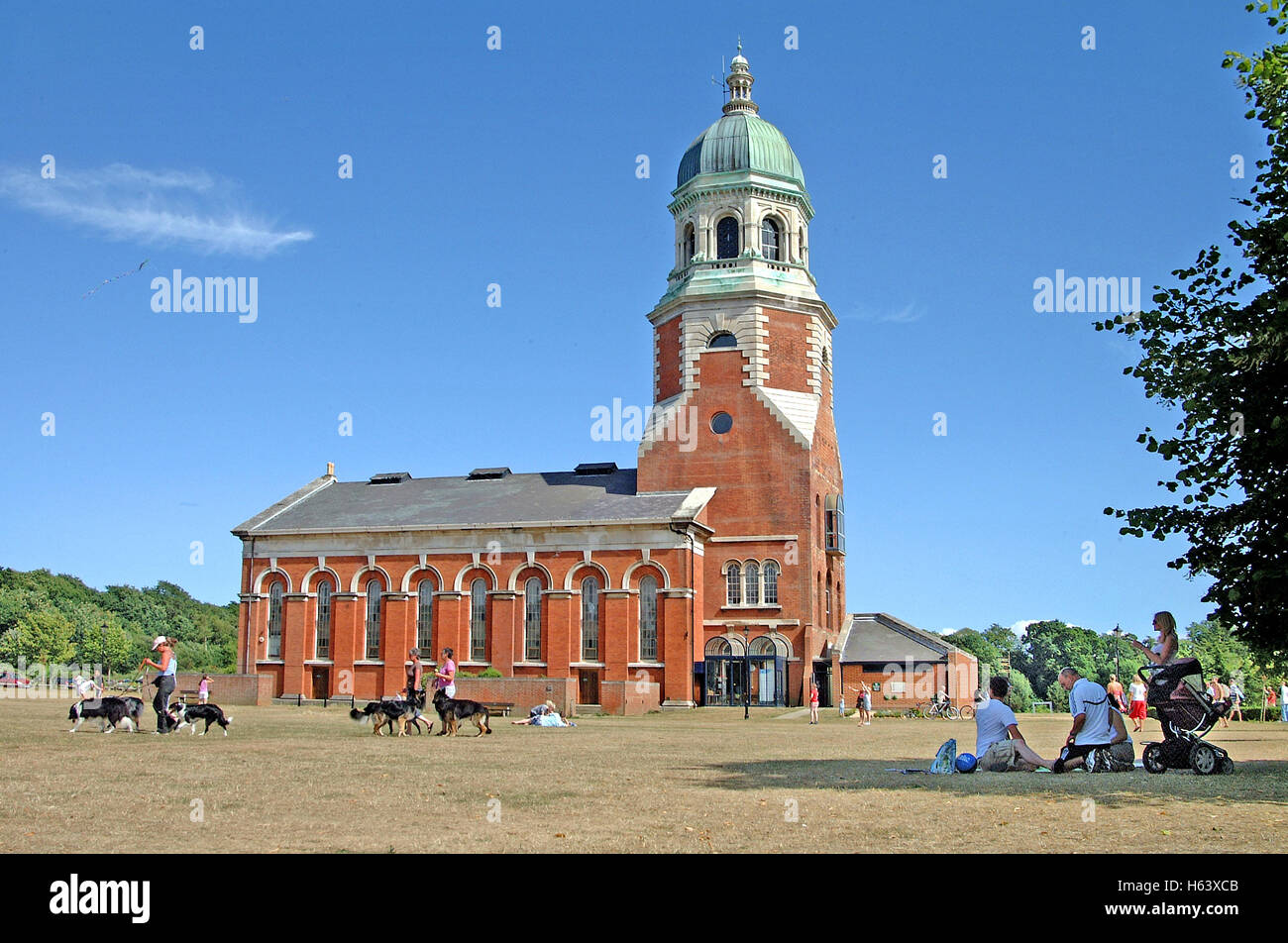 Families picnicking and dog walkers in front of the Chapel at the Royal Victoria Country Park on Southampton Water Hampshire UK Stock Photo