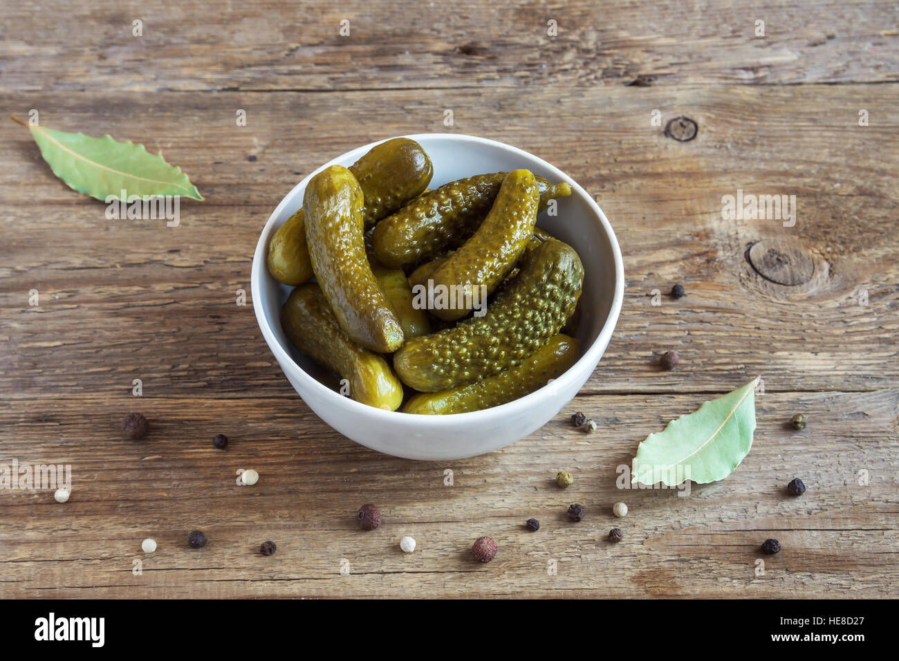 Pickles. Bowl of pickled gherkins (cucumbers) over rustic wooden background close up. Stock Photo