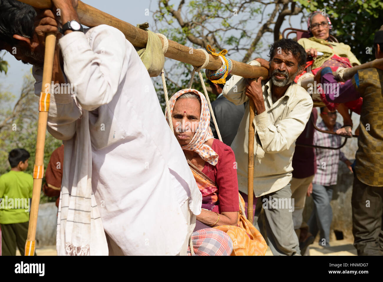 PALITANA, GUJARAT, INDIA - JANUARY 25: Indian pilgrims carried on primitive sedan chairs to the holy Palitana top in the Gujarat state in India, Palit Stock Photo