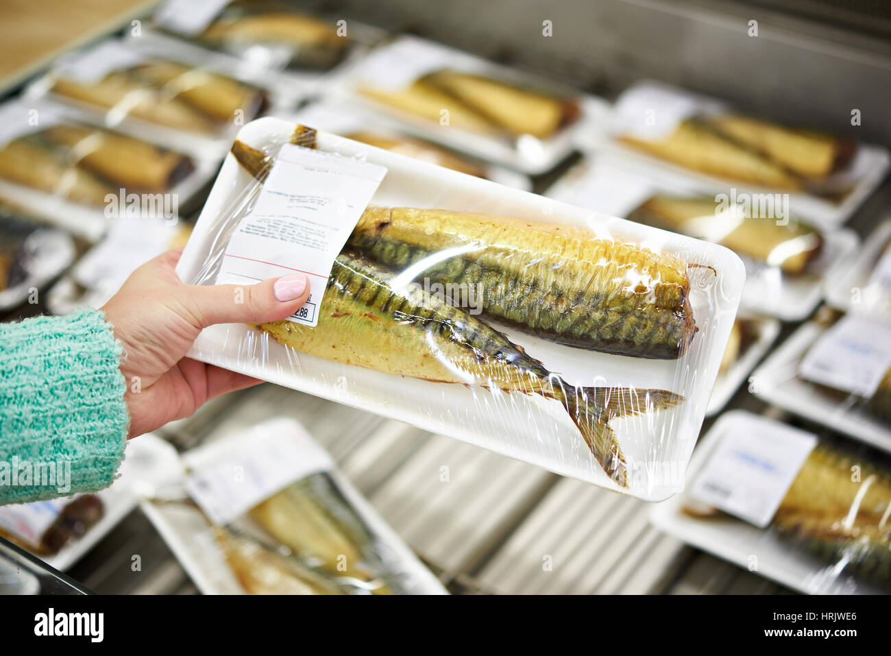 Buyer chooses smoked fish mackerel in supermarket Stock Photo