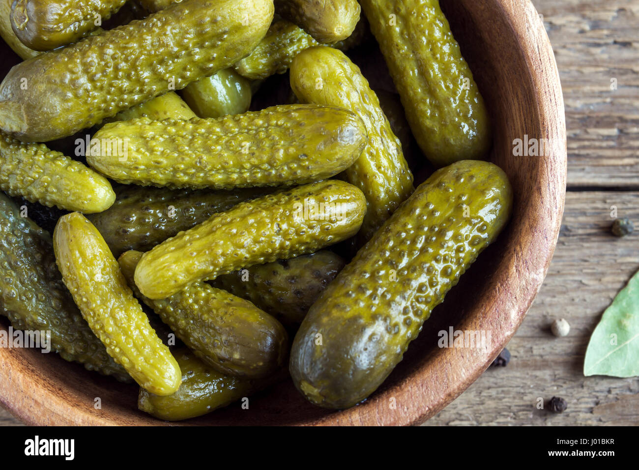 Pickles. Bowl of pickled gherkins (cucumbers) over rustic wooden background close up. Stock Photo