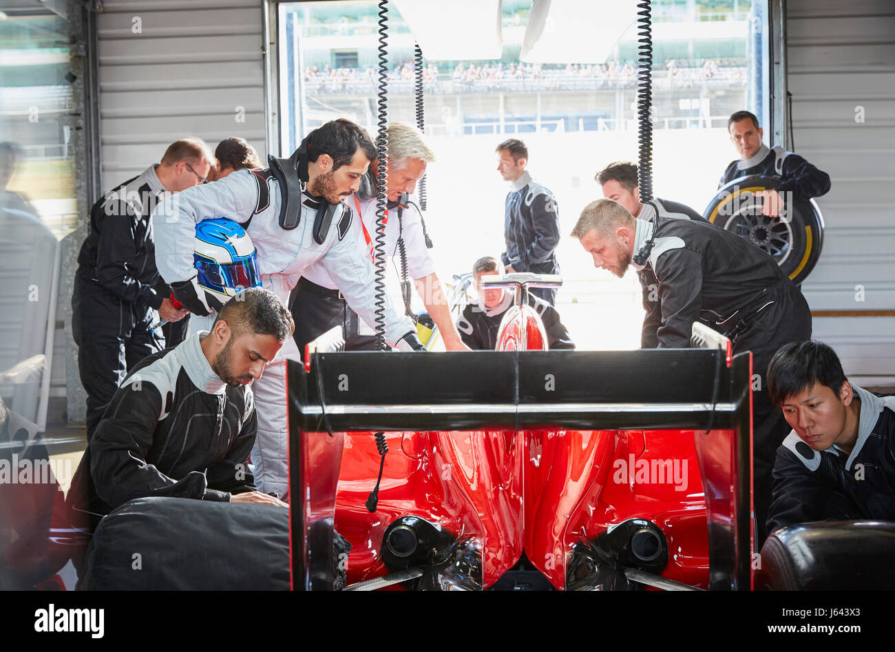 Pit crew preparing formula one race car in repair garage Stock Photo