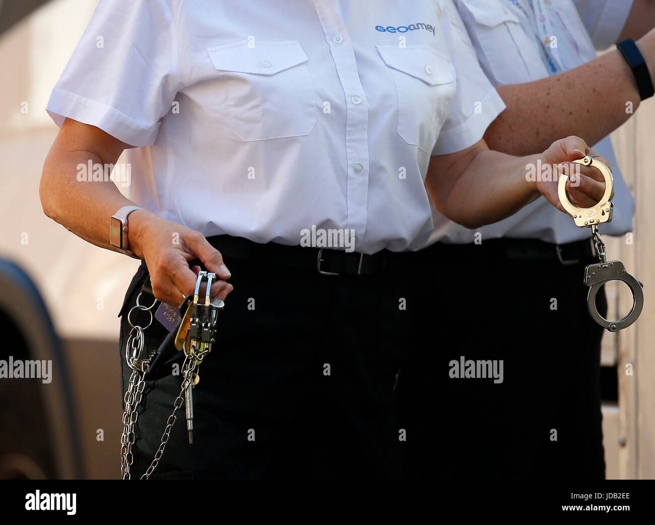 A Geoamey custody officer leads a prisoner into Lewes Crown Court in handcuffs. June 19, 2017. James Boardman / Telephoto Images Stock Photo