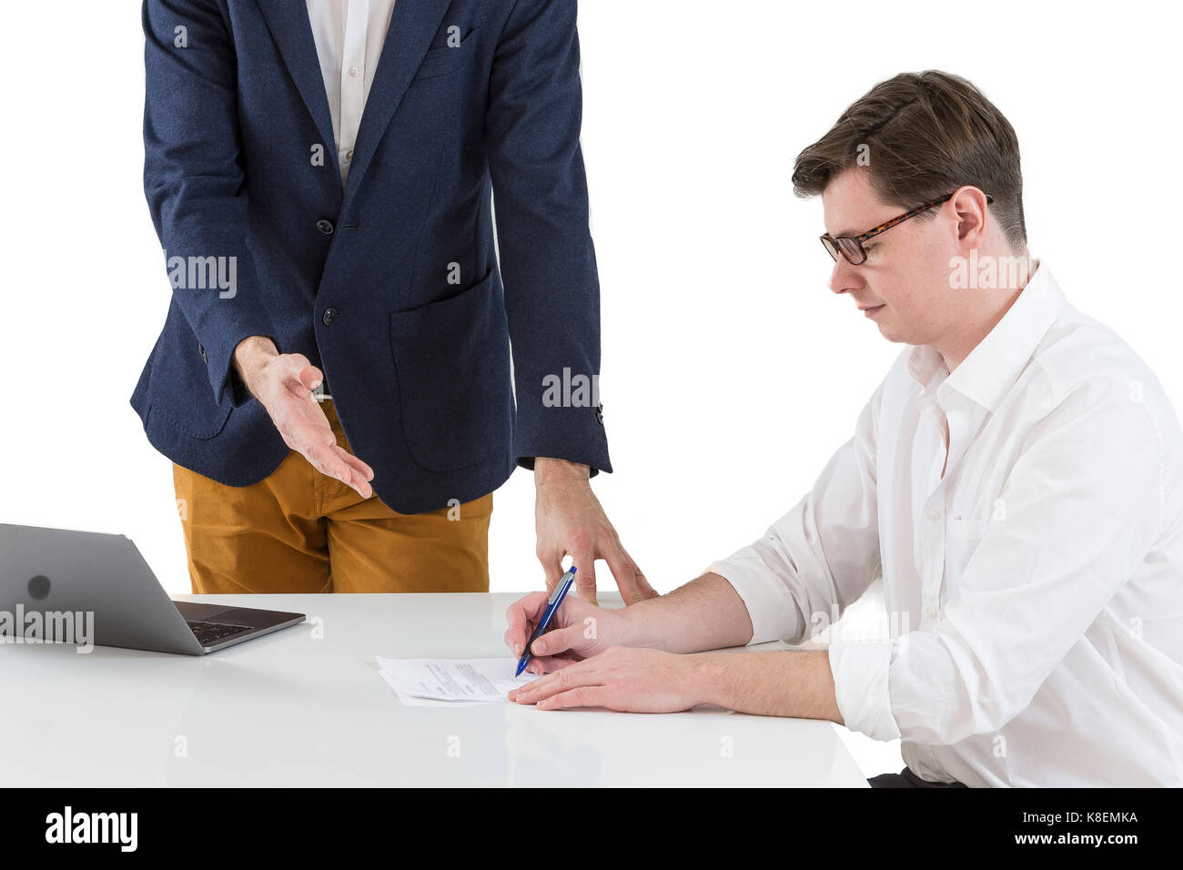 Two young businessmen signing contracts at office desk Stock Photo