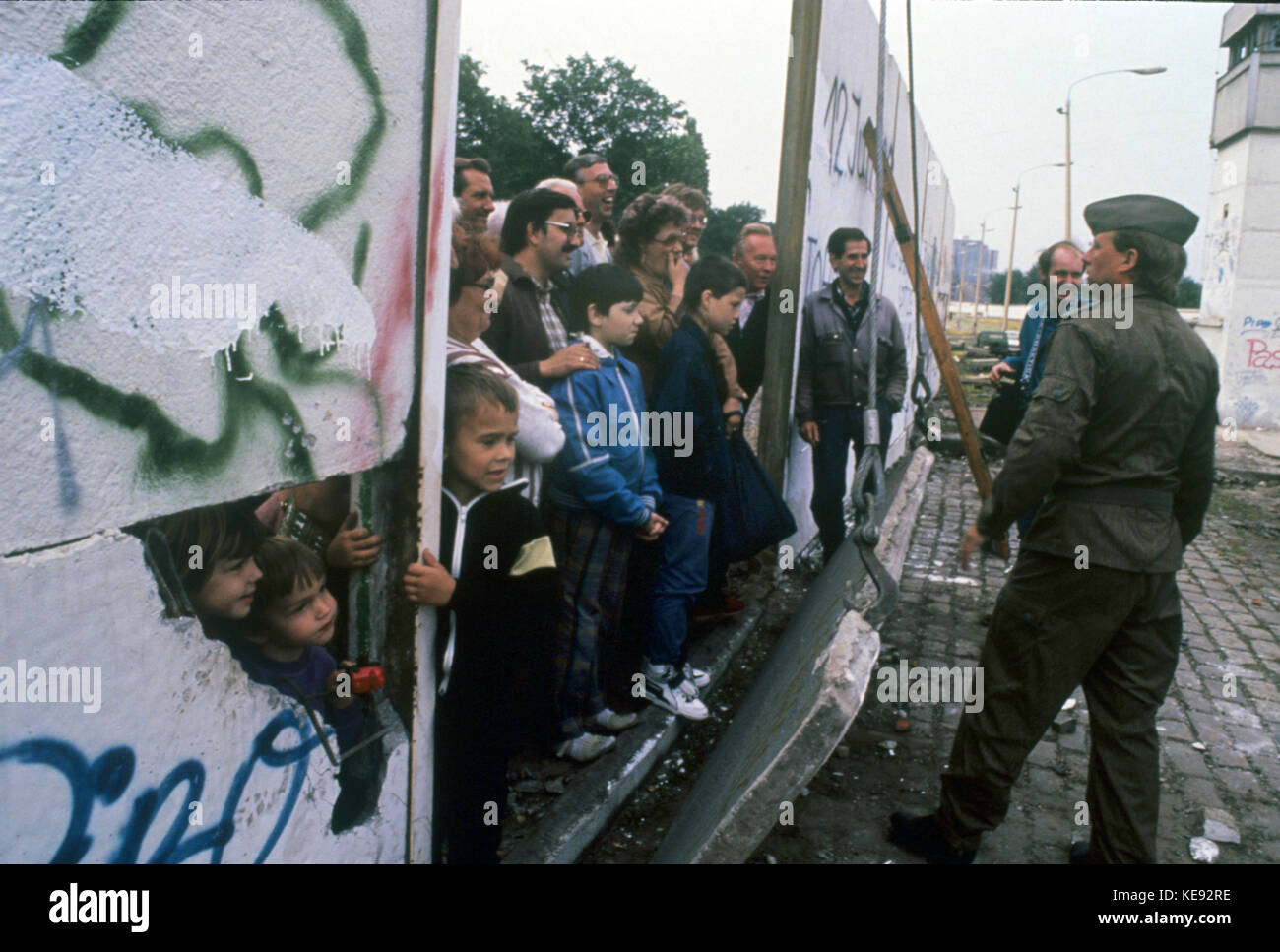 Curious onlookers are observing the demolition of the Berlin Wall at Bernauer street in Wedding (Berlin, Germanny) on 13 June 1990. Germany reunited on the night of 9/10 November 1989. The GDR joined the Federal Republic of Germany on 3 October 1990.  | usage worldwide Stock Photo