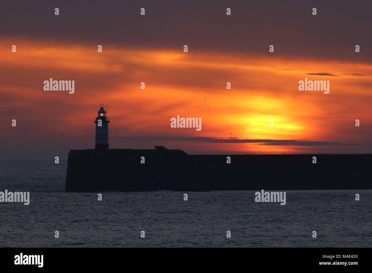 Sunset with Newhaven Lighthouse in East Sussex. Stock Photo