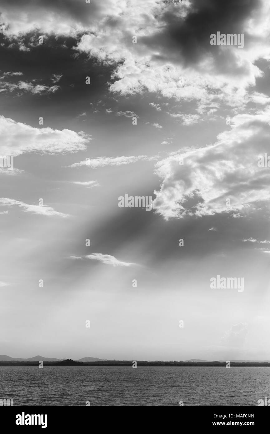 Powerful sun rays coming out through some clouds over Trasimeno  Stock Photo