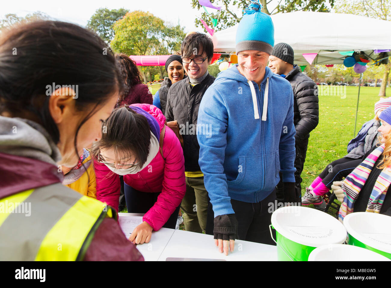 Runners checking in for charity run in park Stock Photo