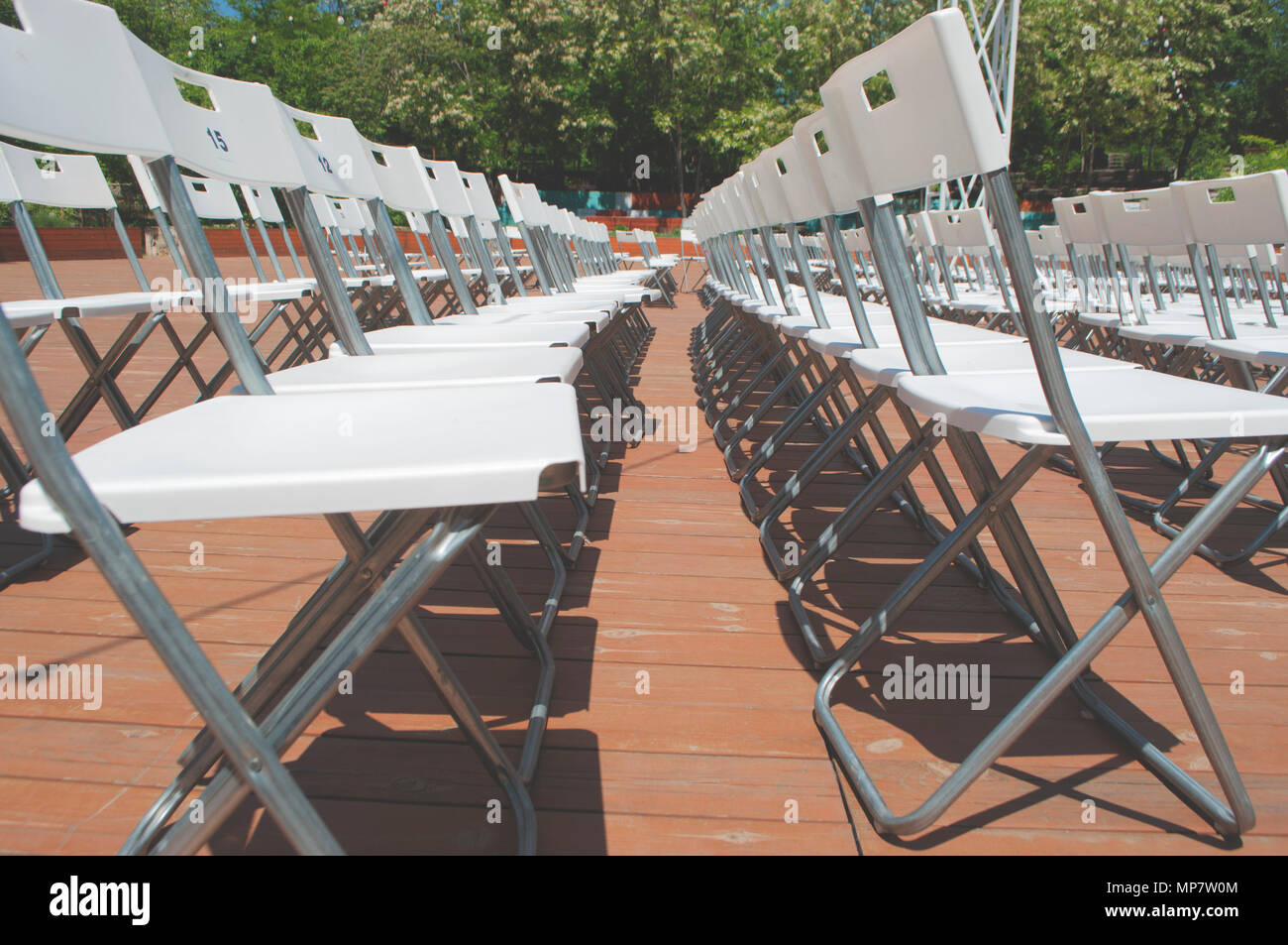 Rows of empty white seats for an outdoor event. Stock Photo