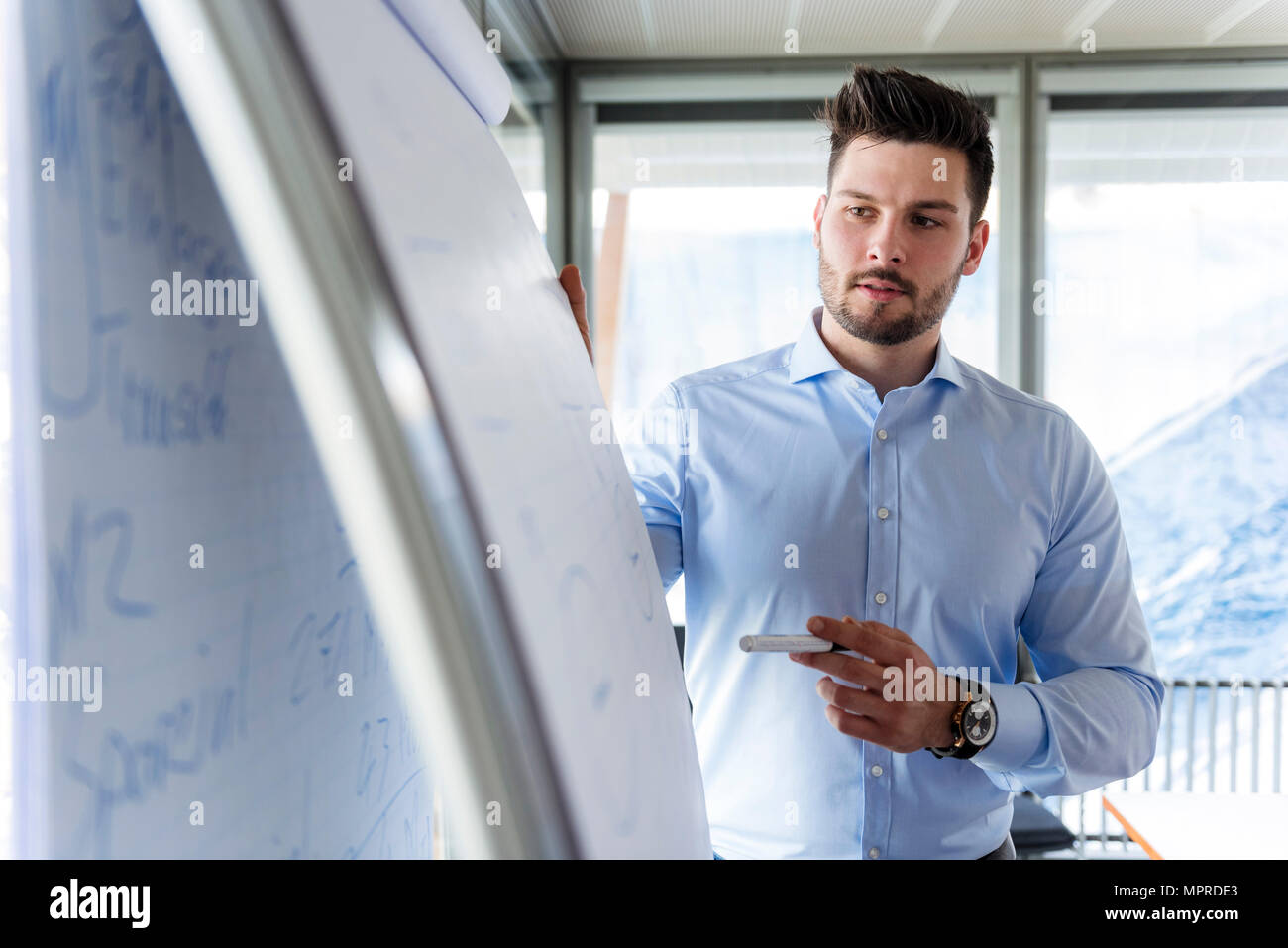 Businessmen standing at flipchart in office Stock Photo