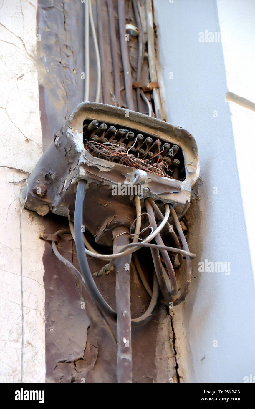 Old broken power cable on a facade Stock Photo