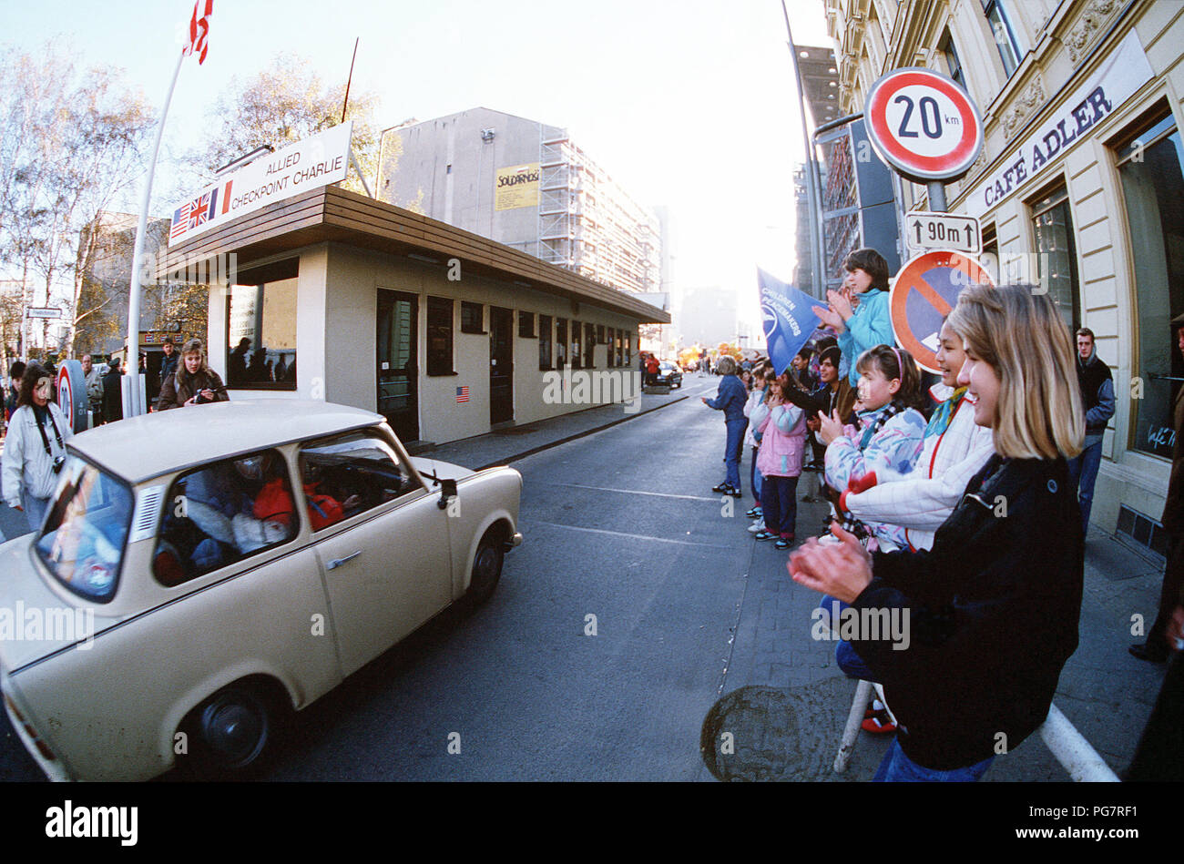 West German children applaud as East German visitors drive through Checkpoint Charlie and take advantage of relaxed travel restrictions to visit the West. Stock Photo