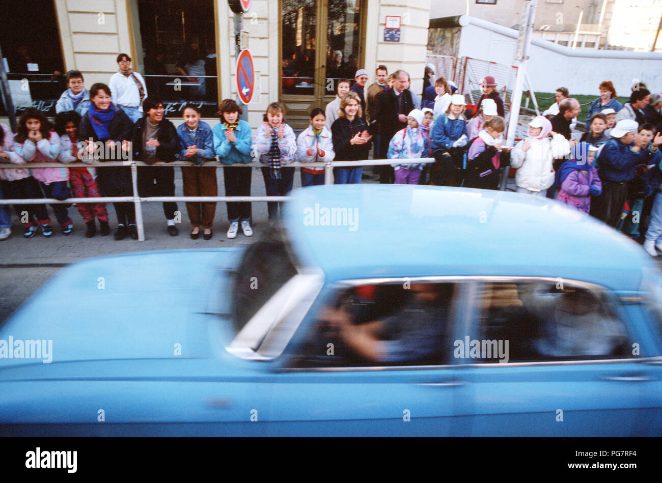 West German children applaud as an East German visitors drive through Checkpoint Charlie and take advantage of relaxed travel restrictions to visit West. Stock Photo