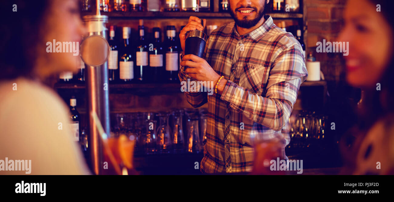 Bartender mixing a cocktail drink in cocktail shaker Stock Photo