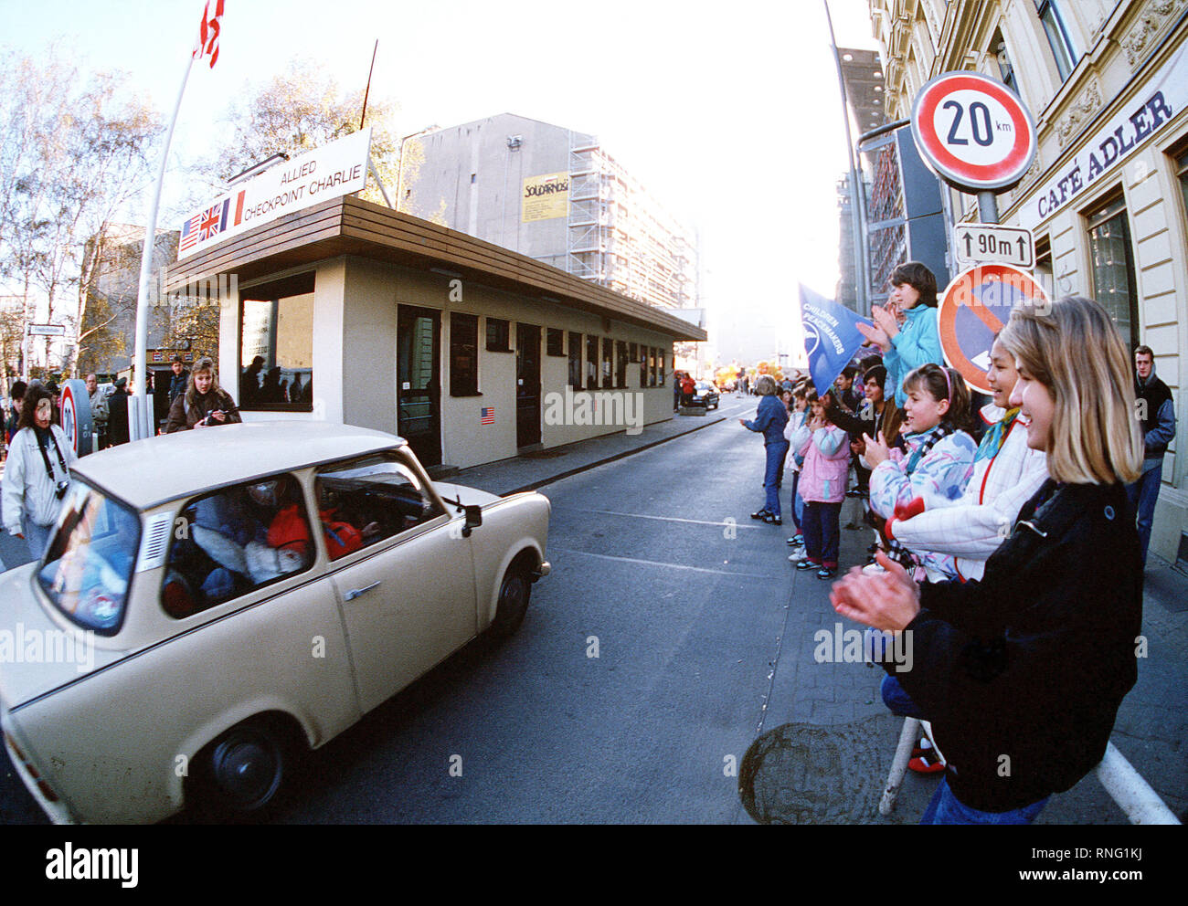 West German children applaud as East German visitors drive through Checkpoint Charlie and take advantage of relaxed travel restrictions to visit the West. Stock Photo